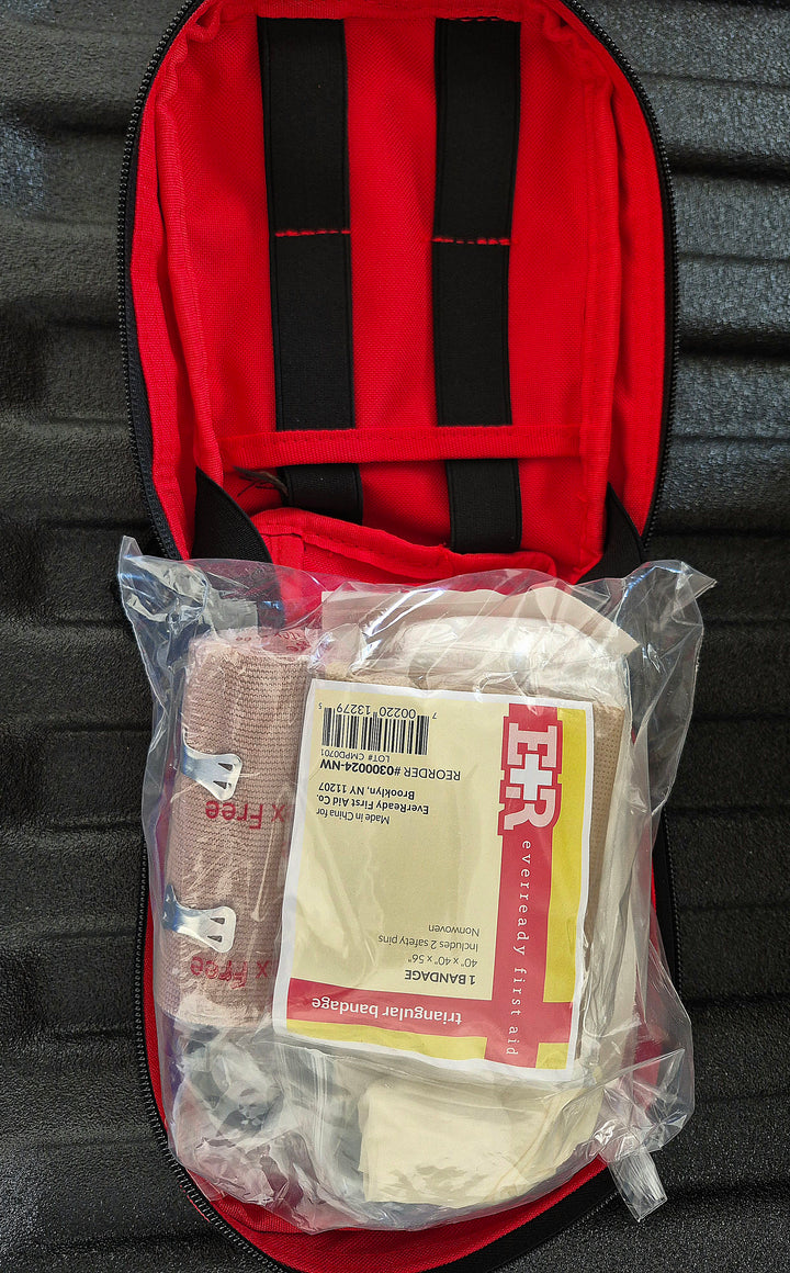 GS-010 Red Molle Medical Pouch unzipped to reveal stocked interior with bandages and gauze behind a clear plastic panel, displayed on textured black background; designed for organized field access and emergency readiness